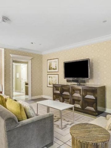 Elegantes Wohnzimmer in einer Hotelsuite mit Sofa und Flachbildfernseher.