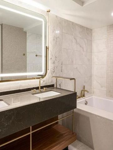 Luxuriöses Badezimmer mit Doppelwaschbecken und beleuchtetem Spiegel.