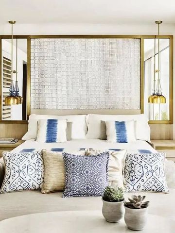 Elegantes Hotelzimmer mit blau-weißer Bettwäsche und dekorativen Kissen.