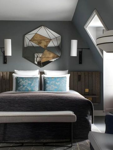Modernes Zimmer unter dem Dach mit kunstvollen Spiegeln und stilvoller Einrichtung