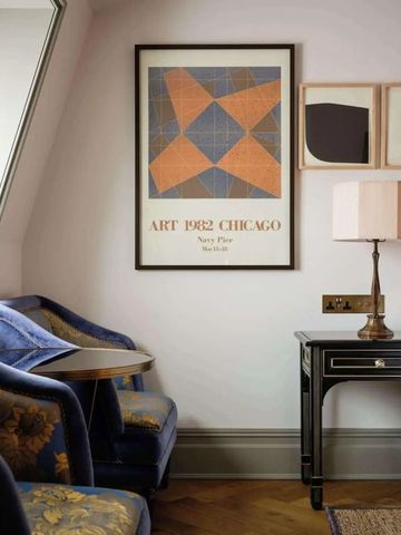 Ecke eines Hotelzimmers mit Kunstwerken und Sessel