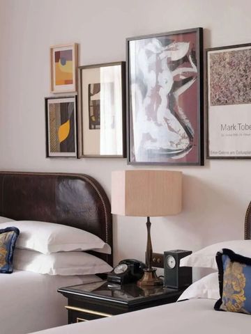 Zwei luxuriöse Einzelbetten mit eleganter Kunst an der Wand.