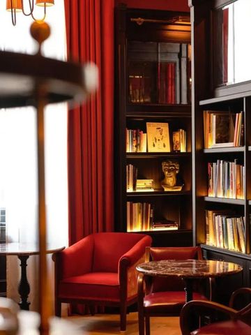 Hoteleinrichtung mit Bücherregalen und roten Sesseln