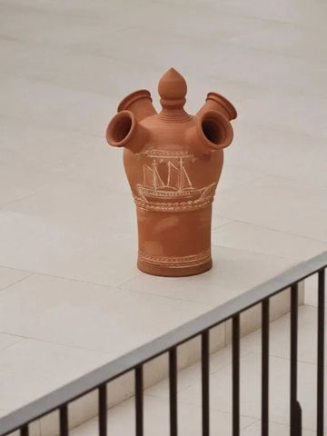 Kunstvoll verzierte Keramikvase auf heller Terrasse
