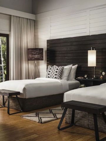 Modernes Doppelzimmer mit Holzverkleidung und großem Fenster im One&Only Nyungwe House
