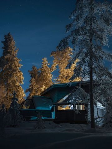 Glass Igloo Suite mit beleuchteten Glaswänden zwischen Kiefern in einer Herbstnacht