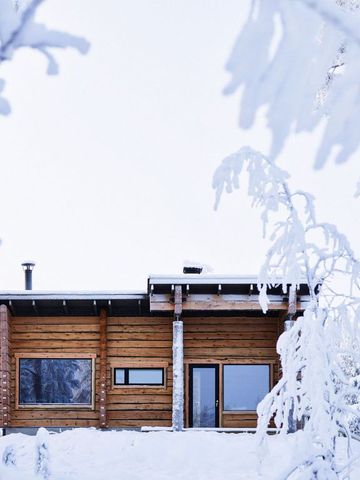 Holzhaus der Monaco-Sauna zwischen schneebedeckten Bäumen im Winter