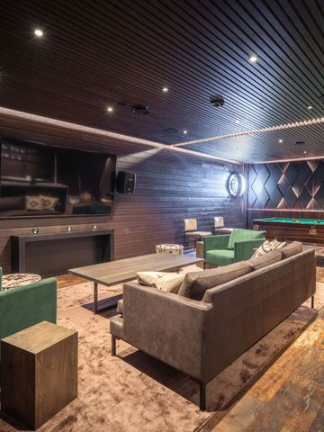 Lounge mit grünen Sesseln, Kamin und Billardtisch in der Ultra Lodge