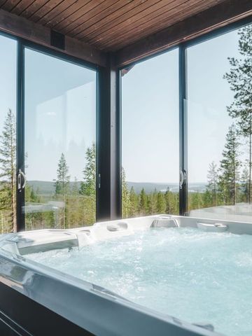 Hot Tub auf der verglasten Terrasse einer Villa-Suite mit Blick über den Wald