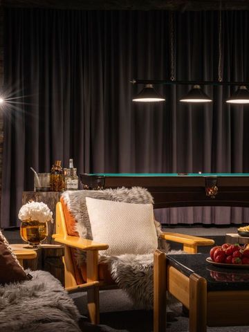 Games Den mit Billardtisch, Fellsesseln und Rundholzwänden im Abendlicht