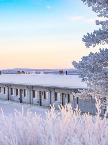Gebäude der Aurora Radar Station zwischen verschneiten Bäumen bei klarem Himmel