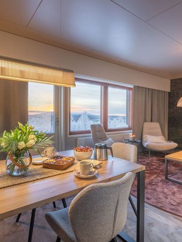 Apartment der Aurora Radar Station mit Esstisch, Sofa und Fenster zur Schneelandschaft