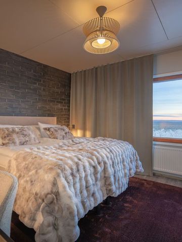 Schlafzimmer der Aurora Radar Station mit Felldecke auf dem Bett und Fenster zum Fjell