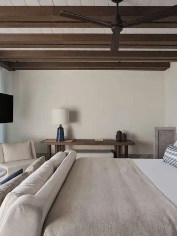 Geräumiges Schlafzimmer mit Holzbalkendecke und moderner Einrichtung