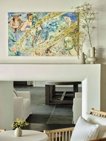 Elegante Sitzecke mit kunstvollem Wandgemälde und Blumenarrangement
