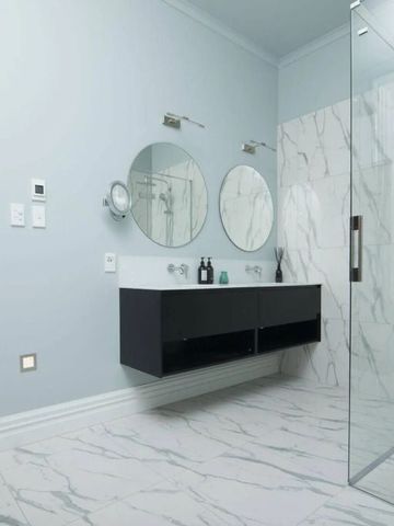 Elegantes Badezimmer mit Marmorfliesen und großer Dusche