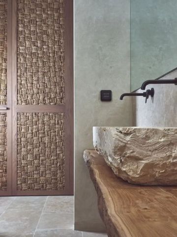 Elegantes Badezimmer mit Natursteinwaschbecken und Holzdetails