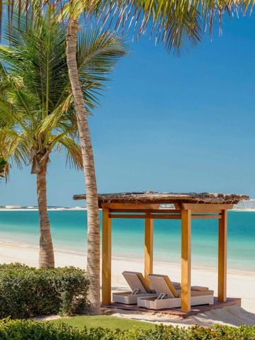 Sonniger Strand mit einem eleganten Baldachin und zwei Liegen