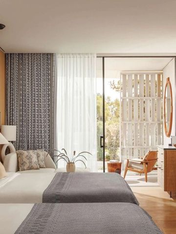 Elegantes Hotelzimmer mit zwei Betten, stilvoll eingerichtet und lichtdurchflutet