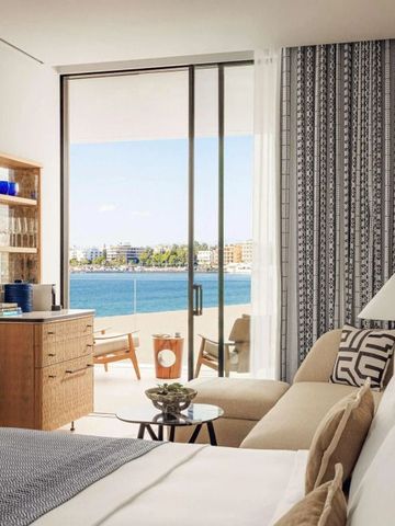 Hotelzimmer mit Blick auf das blaue Meer durch große Glastüren