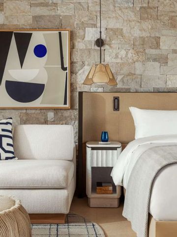 Stilvoll eingerichtetes Hotelzimmer mit Kunstwerk an der Wand und gemütlicher Sitzecke