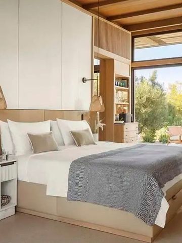 Zimmer mit großen Fenstern und Ausblick auf die grüne Landschaft