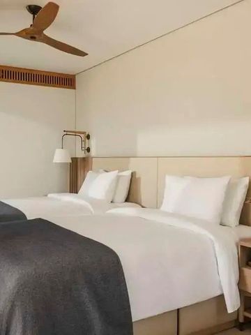 Geräumiges Hotelzimmer mit zwei Einzelbetten, modernem Design und Holzakzenten