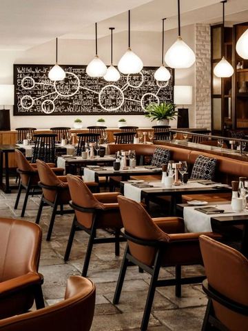 Edle Restaurant-Innenausstattung mit Lederstühlen und Kunstwand