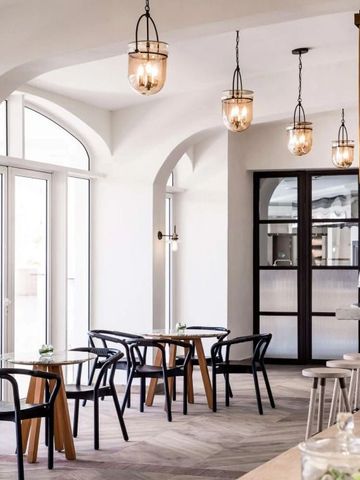 Helle Café-Area mit eleganten Bögen und hängenden Lampen