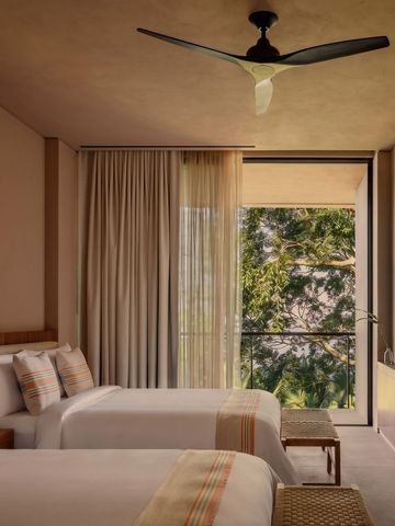 Moderne Suite mit zwei Einzelbetten und großem Fenster mit Gartenblick