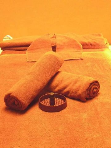Wellnessbereich mit Massagebett und warmen Tüchern