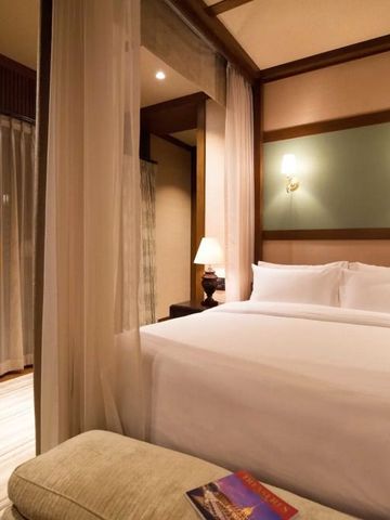 Gemütliches Schlafzimmer mit Doppelbett und eleganten Vorhängen
