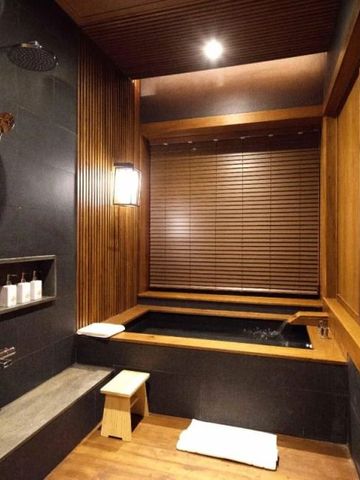 Luxuriöses Badezimmer mit Holzverkleidung und Dusche im Onsen-Stil.