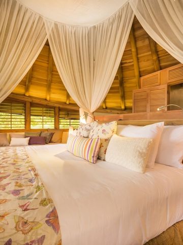 Großzügiges Schlafzimmer unter Baldachin mit eleganten Stoffen