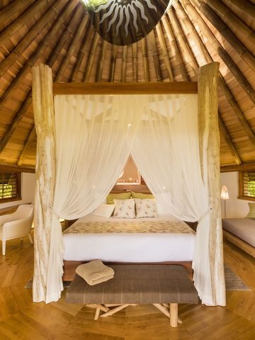 Luxuriöses Schlafzimmer mit Himmelbett und Bambusdecke
