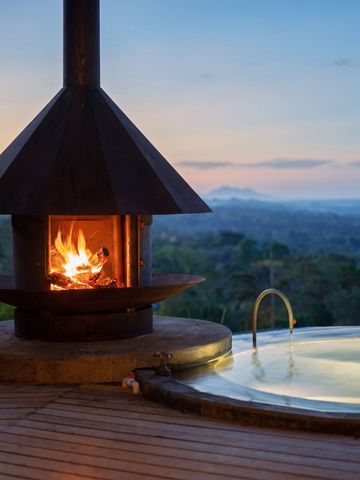 Privater Whirlpool mit Blick auf die Landschaft und einem Kamin daneben