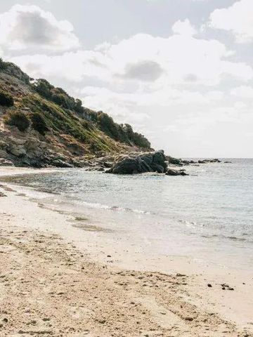 Abgeschiedener Strand mit klarem Wasser und felsiger Landschaft