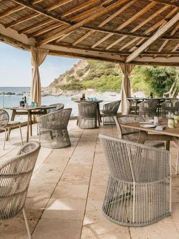 Strandrestaurant mit rustikalem Dach und Blick auf das Meer