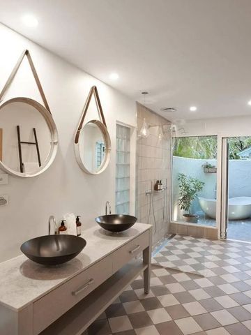 Modernes Badezimmer mit Doppelwaschbecken und Zugang zur Terrasse