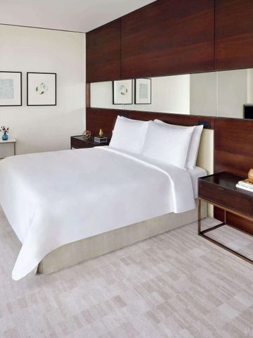 Modernes Hotelzimmer mit Doppelbett und schlichter Dekoration im Address Sky View