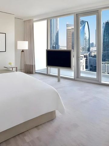 Elegantes Hotelzimmer mit Blick auf die Skyline von Dubai durch große Glasfenster