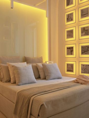 Gemütliches Schlafzimmer mit stilvoller Beleuchtung und Kunst an der Wand