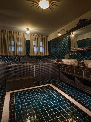 Elegantes Badezimmer mit dunklen Fliesen und Doppelwaschbecken