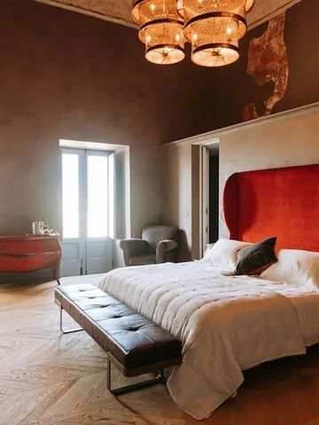 Elegantes Doppelzimmer mit rotem Kopfteil und Designerleuchte