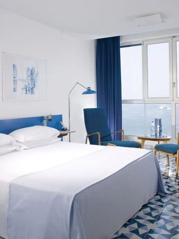 Helles Hotelzimmer mit Meerblick und blau-weißer Einrichtung
