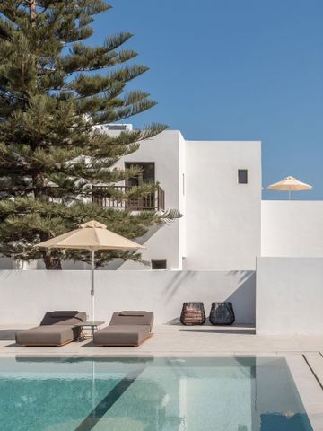 Pool mit Liegestühlen in modernem Design und Blick auf weiße Gebäude