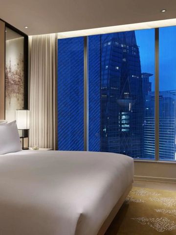 Komfortables Hotelzimmer mit modernem Design und Blick auf die beleuchteten Gebäude