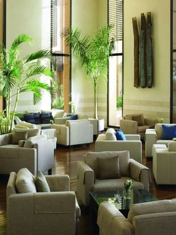 Elegante Lobby mit stilvollen Sesseln und hohen Pflanzen bei Tageslicht