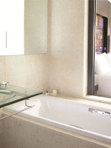 Helles Badezimmer mit Badewanne und stilvollem Waschbereich