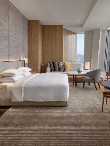 Modernes Hotelzimmer mit großem Bett und Panoramablick auf die Stadt